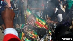 Supporters of the opposition Movement for Democratic Change party (MDC) of Nelson Chamisa burn an election banner with the face of Zimbabwe's President Emmerson Mnangagwa in Harare, Zimbabwe, Aug. 1, 2018.