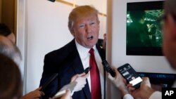 President Donald Trump speaks with reporters on Air Force One while in flight from Andrews Air Force Base, Md., to Palm Beach International Airport, Florida, April 6, 2017. 