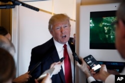 President Donald Trump speaks with reporters on Air Force One while in flight from Andrews Air Force Base, Md., to Palm Beach International Airport, Florida, April 6, 2017.