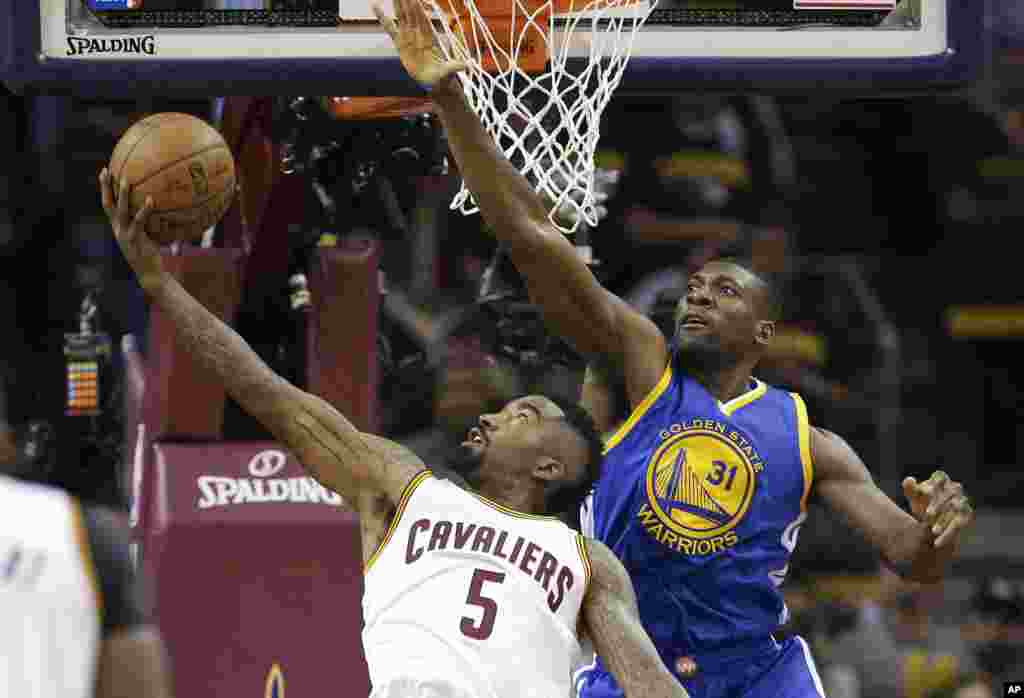 Festus Ezeli (31) milieu de Golden State Warriors bloque une tentative de JR Smith (5) de Cavaliers au cours de Cleveland lors de la première mi-temps du 6e match des finales de basketball de la de Cleveland, mardi 16 Juin 2015.