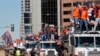 Members of the Denver Broncos wave to adoring fans from atop a fleet of firetrucks during a Super Bowl victory parade in Denver, Feb. 9, 2016.