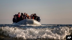 Refugees and migrants approach the Greek island of Lesbos on a dinghy after crossing the Aegean sea from the Turkish coast, on Monday, Dec. 7, 2015. 