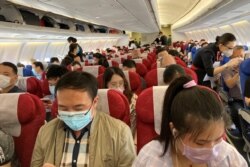 Penumpang mengenakan masker dalam pesawat China Eastern Airlines di Bandara Internasional Shenzhen Baoan di Shenzhen, provinsi Guangdong, China, 19 Mei 2020.