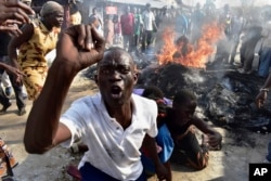 A opposition supporter reacts after burning tyres during demonstrations in Mombasa, Kenya, Oct. 26, 2017.