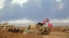 Smoke rises as the Iraqi army, supported by volunteers, battles Islamic State extremists outside Tikrit, March 4, 2015.