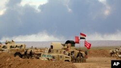 Smoke rises as the Iraqi army, supported by volunteers, battles Islamic State extremists outside Tikrit, March 4, 2015.