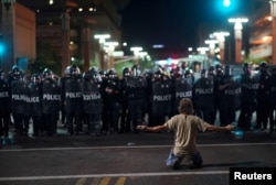 A demonstrator taunts Police officials after a Donald Trump campaign rally in Phoenix, Arizona, U.S. August 22, 2017.