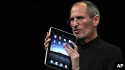 Apple Chief Executive Officer Steve Jobs holds the new 'iPad' during the launch of Apple's new tablet computing device in San Francisco, California