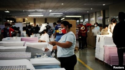 Empleados trabajan en una imprenta donde el gobierno hondureño está imprimiendo la papeleta que se utilizará en las elecciones generales del 28 de noviembre, en Tegucigalpa, Honduras, 13 de noviembre de 2021.