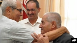 2015年10月9日获得诺贝尔和平奖的突尼斯全国对话四方集团之一的突尼斯总工会（UGTT）秘书长 艾巴西（右）在突尼斯首都办公室接受祝贺
