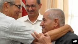 Houcine Abassi, secretary general of the Tunisian General Labour Union (UGTT), right, is congratulated by unidentified union members in his office at the headquarters in Tunis, Tunisia, Friday, Oct. 9, 2015. Abassi is one of the four members of the Tunisian National Dialogue Quartet to be awarded the 2015 Nobel Peace Prize on Friday by the Norwegian Nobel Committee. (AP Photo)