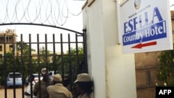 Ugandan police officers stand by the entrance of the Esella Country Hotel after police raided a gay rights workshop which was taking place in the hotel in Kampala, June 18, 2012.