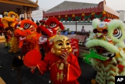 Members of Cambodia's Chinese community perform a traditional lion dance during the lunar new year Monday, Feb. 4, 2019, in front of Royal Palace, in Phnom Penh, Cambodia. (AP Photo/Heng Sinith)