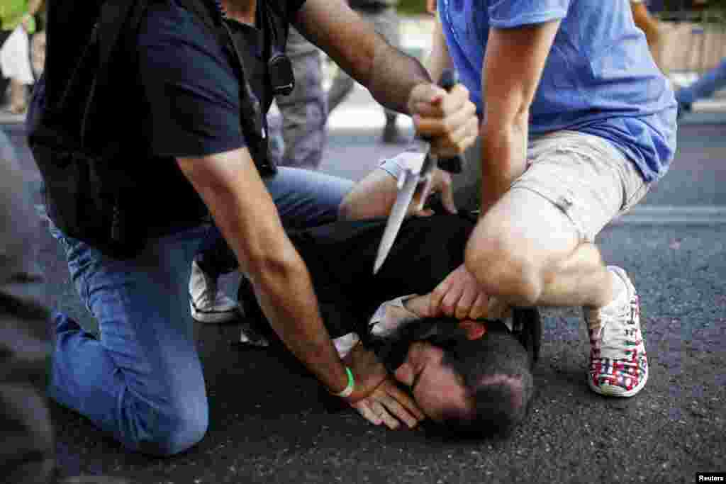 People disarm an Orthodox Jewish assailant shortly after he stabbed participants at the annual Gay Pride parade in Jerusalem. Six participants were wounded during the march, police said.