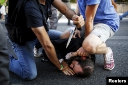 People disarm an Orthodox Jewish assailant shortly after he stabbed participants at the annual Gay Pride parade in Jerusalem July 30, 2015.