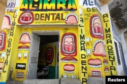 Somali dentist Hassan Ali, 35, sits inside his dental clinic with murals painted on the walls in Hamarweyne district of Mogadishu, Somalia, June 7, 2017.