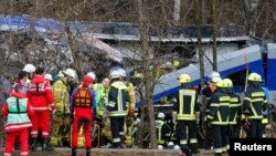 Anggota regu penyelamat berdiri di sekitar lokasi kecelakaan dua kereta dekat Bad Aibling di Jerman selatan (9/2).