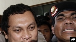Tax official Gayus Tambunan is escorted by police officers as he arrives at a district court for his corruption trial in Jakarta, Indonesia, Wednesday, Jan. 19, 2011