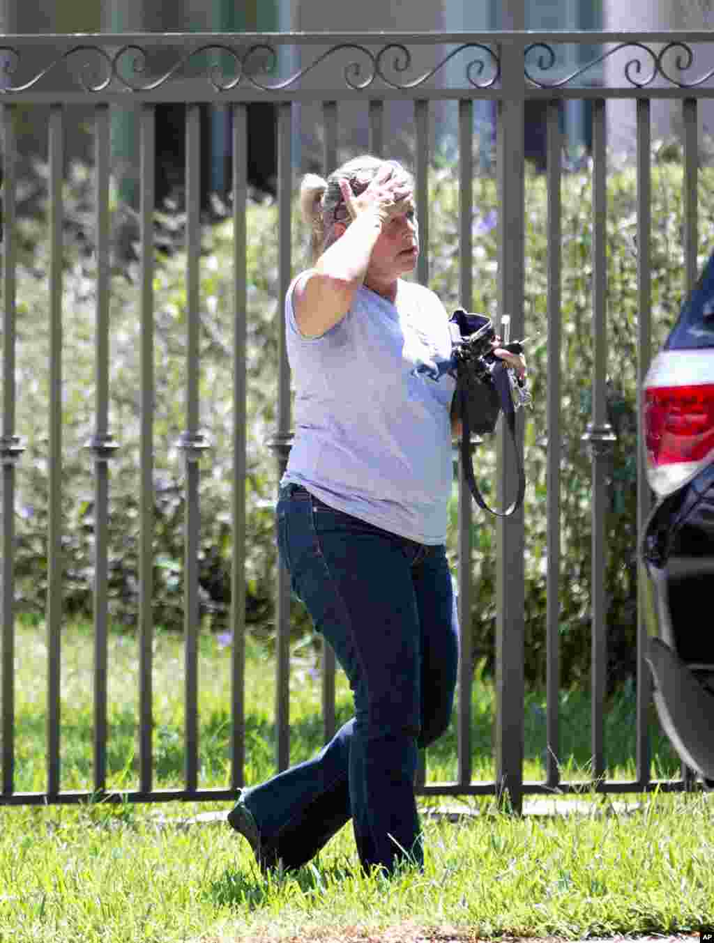 Seorang perempuan yang tidak diketahui identitasnya berjalan ke rumah keluarga wartawan Steven Sotloff, di Pinecrest, Florida, 2 September 2014.
