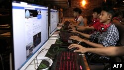 FILE - This picture taken on Dec. 18, 2018 shows Myanmar youths browsing their Facebook page at an internet shop in Yangon.