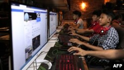 FILE - This picture taken on Dec. 18, 2018 shows Myanmar youths browsing their Facebook page at an internet shop in Yangon.