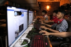 FILE - This picture taken on Dec. 18, 2018 shows Myanmar youths browsing their Facebook page at an internet shop in Yangon.