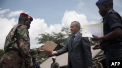 FILE - Victor Tokmakov, first secretary of the Russian Embassy, presents graduation diplomas to graduating recruits in Berengo, Aug. 4, 2018. Russian military consultants set up training for the Central African Armed Forces after delivering weapons to the country. 