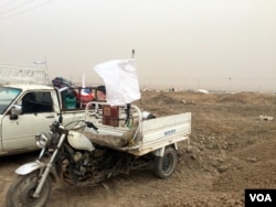 While many families flee on foot, those in their own cars hang white flags to indicate they are not with any military organization in Kurdish, Iraq, Nov. 1, 2016. (H. Murdock/VOA)