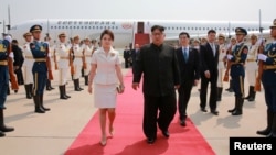 North Korean leader Kim Jong Un and his wife Ri Sol Ju walk upon arriving in Beijing, China, in this undated photo released June 20, 2018 by North Korea's Korean Central News Agency.