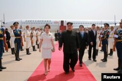 North Korean leader Kim Jong Un and his wife Ri Sol Ju walk upon arriving in Beijing, China, in this undated photo released June 20, 2018 by North Korea's Korean Central News Agency.