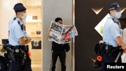 2021年6月24日一位香港市民阅读最后一期《苹果日报》