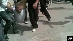 A still image taken from an amateur video purportedly taken on April 22, 2011 shows a protester being carried by a group of other protesters during a demonstration in the city of Homs, Syria