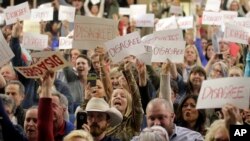 People react to Rep. Jason Chaffetz as he speaks during a town hall meeting, Feb. 9, 2017, in Cottonwood Heights, Utah. Hundreds of people lined up early for the town hall with Chaffetz, many holding signs criticizing the congressman's push to repeal the newly named Bears Ears National Monument in southern Utah.