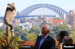 FILE - U.S. Vice President Mike Pence looks at a koala with his daughters, Charlotte and Audrey, and a keeper during a visit to Taronga Zoo in Sydney, Australia, April 23, 2017.
