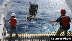 MBARI Scientists aboard Research Vessel Western Flyer shown recovering a water sampling device in the North Pacific Ocean, which is used to collect algae. (photo credit: Adam Monier)