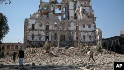 Houthi Shiite rebels walk amid the rubble of the Republican Palace that was destroyed by Saudi-led airstrikes, in Sanaa, Yemen, Dec. 6, 2017. (AP Photo/Hani Mohammed)