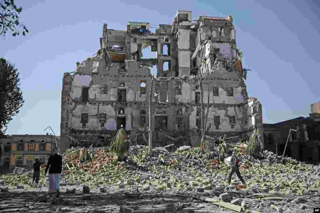 Houthi Shi&#39;ite rebels walk amid the rubble of the Republican Palace that was destroyed by Saudi-led airstrikes, in Sana&#39;a, Yemen.