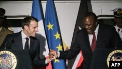 FILE - French President Emmanuel Macron, left, shakes hands with Kenyan President Uhuru Kenyatta during an event at Nairobi Central Railway Station in Nairobi, March 13, 2019, on the first day of a state visit to Kenya.