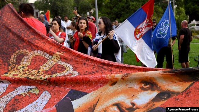 Members of the local Serbian community hold flags and banners outside a government detention center where Serbia's tennis champion Novak Djokovic is staying in Melbourne, Australia, on Jan. 8, 2022.