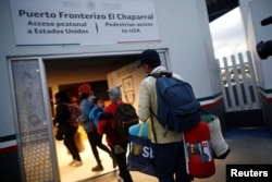 Members of a caravan of migrants from Central America enter the United States border and customs facility, where they are expected to apply for asylum, in Tijuana, Mexico, May 2, 2018.