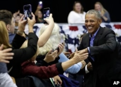 Former President Barack Obama, right, greets Democratic supporters at Genesis Convention Center, Sunday, Nov. 4, 2018, in Gary, Ind.