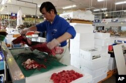 A fish retailer at the Onahama fish market in Iwaki City, Fukushima, cuts up tuna fish from Miyazaki, southern Japan, Oct. 12, 2017. Demand has slumped for Fukushima fish thanks to the lack of public awareness and confidence about fish safety since the 2011 nuclear disaster.