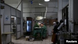 FILE - Doctors treat an injured civilian in a field hospital after what activists said was shelling by forces of Syria's President Bashar al-Assad in the Douma neighbourhood of Damascus, Eastern Ghouta, Syria November 19, 2015.