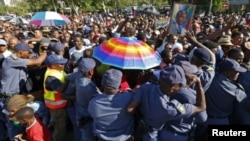 South African police try to block mourners at a checkpoint while they attempt to walk to the Union building to see the body of former South African President Nelson Mandela, in Pretoria, Dec. 13, 2013. 