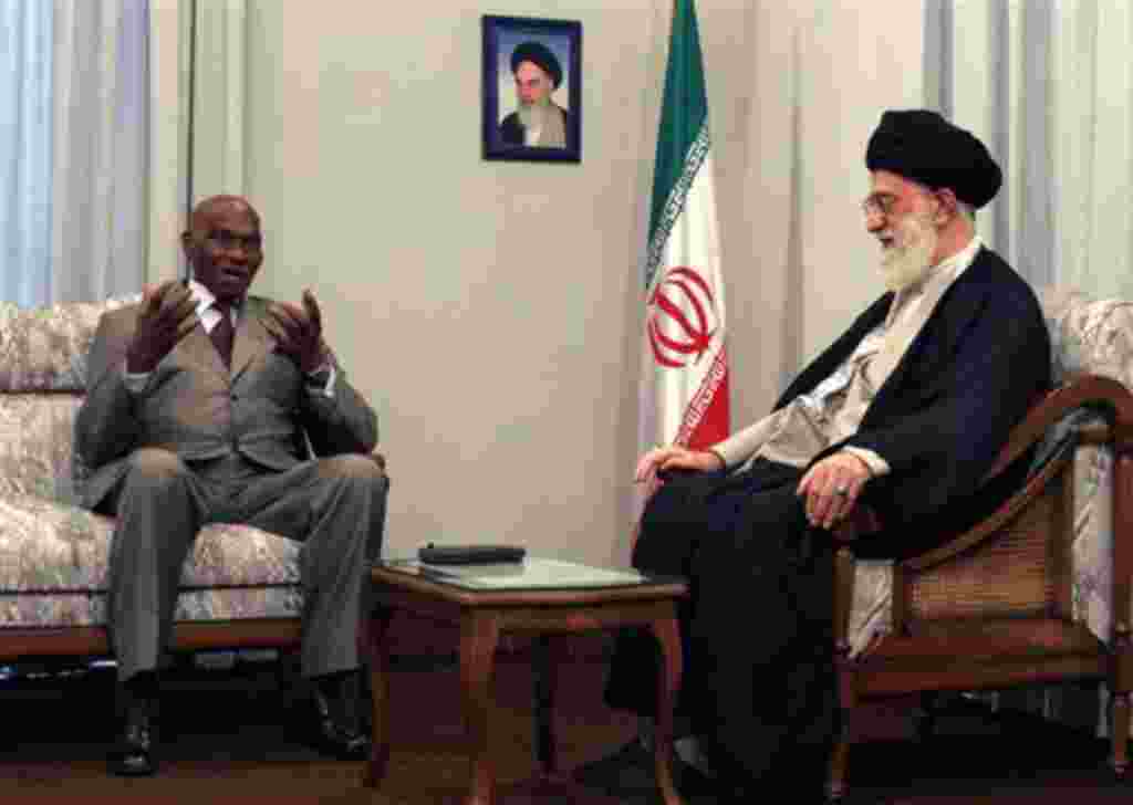 Under a picture of Iran's late revolutionary founder Ayatollah Khomeini, Senegalese President Abdoulaye Wade, left, talks with Iranian supreme leader Ayatollah Ali Khamenei, during their official meeting in Tehran, Iran, Tuesday, June 27, 2006. (AP Photo/