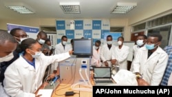 In this photo taken Monday, April 13, 2020, medical students test a self-designed computer-controlled ventilator prototype at the Chandaria Business and Incubation Centre of Kenyatta University in Nairobi, Kenya. (AP PHOTO/John Muchucha)