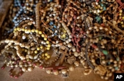 A pile of necklaces and crucifixes belonging to some of those who were slaughtered as they sought refuge inside the church sit on the altar as a memorial to the thousands who were killed during the 1994 genocide in Rwanda.