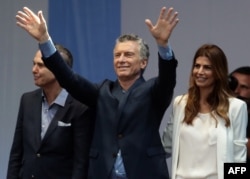 El presidente de Argentina, Mauricio Macri (centro) jnunto a su compañero de fórmula a la vicepresidencia Miguel Angel Pichetto (izquierda) y la primera dama Juliana Awada durante un acto de campaña en Buenos Aires, el 19 de octubre, de 2019.
