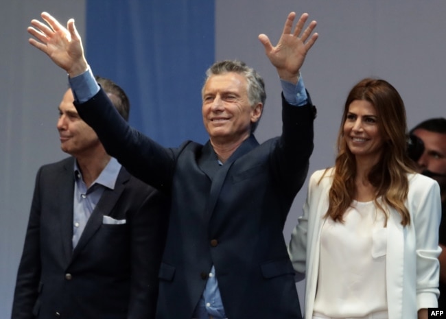 El presidente de Argentina, Mauricio Macri (centro) jnunto a su compañero de fórmula a la vicepresidencia Miguel Angel Pichetto (izquierda) y la primera dama Juliana Awada durante un acto de campaña en Buenos Aires, el 19 de octubre, de 2019.