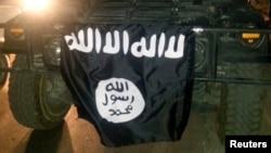 FILE - Islamic State display their flag during celebrations in Mosul, Iraq.